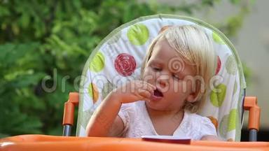 小女孩<strong>坐椅子</strong>和吃葡萄